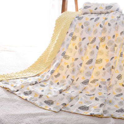 Baby Doudou blanket with 3D hot-pressed bubble design, featuring yellow and gray nature-themed patterns, draped over a chair.