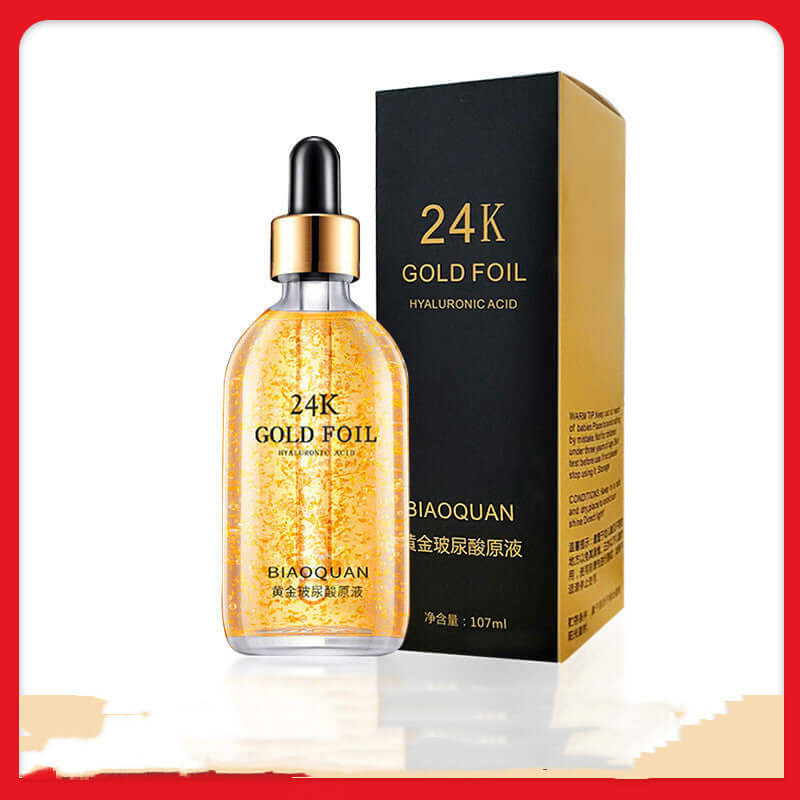 24K gold foil skin care serum with hyaluronic acid in a clear bottle, next to its black packaging box.