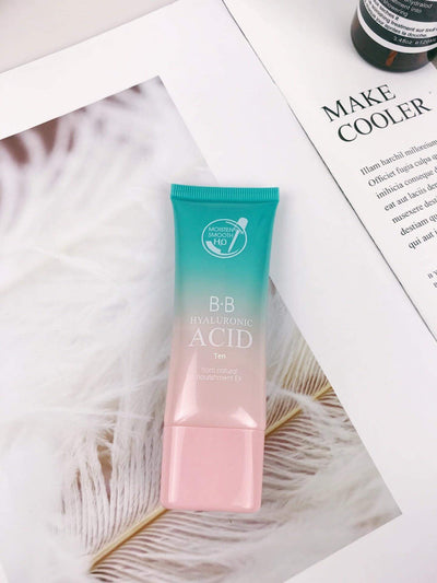 Hyaluronic acid BB cream tube on a soft feather background with printed skincare advertisement.